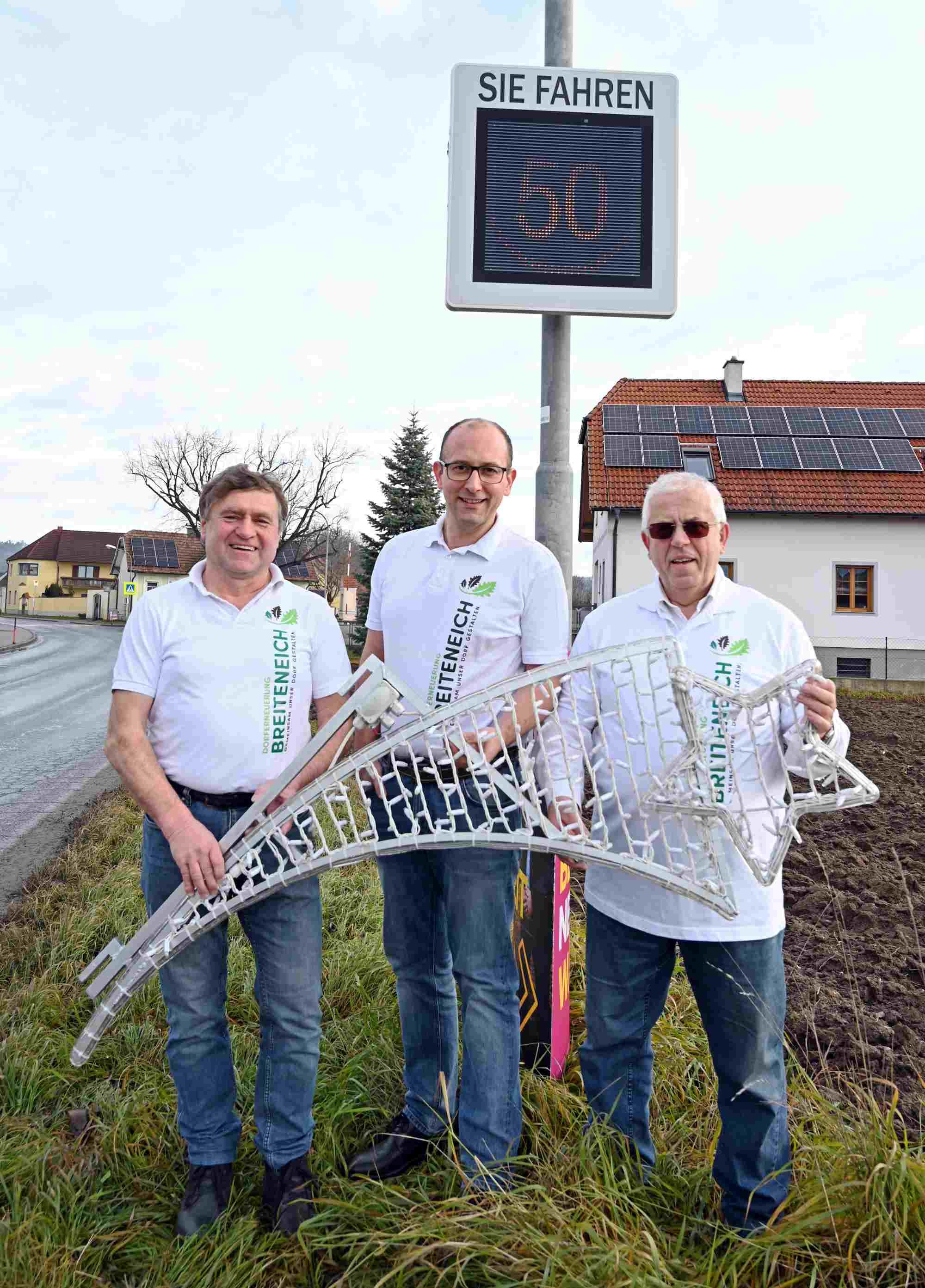 Wilhelm Amon, OV GR Stefan Keusch und Obmann Josef Amon (v. l.) zeigen einen Teil der neu erworbenen Weihnachtsbeleuchtung vor einer der beiden neuen Geschwindigkeitsanzeigen. Foto: Gabriele Hohenegger 